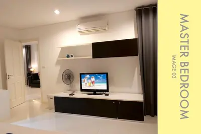 a living room with a flat screen tv on a counter at Pool Access 2 BDR Stylish Condo in Kamala Beach