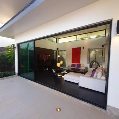 a living room with a large sliding glass door at Eden Villa Phuket in Bang Tao Beach