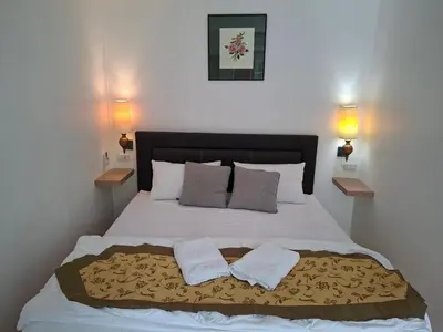 a bedroom with a bed with two towels on it at Suwita House in Nai Yang Beach
