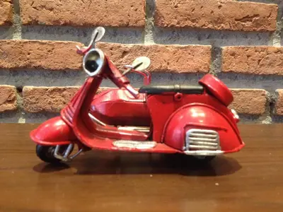 a small red scooter parked next to a brick wall at Dfeel House in Patong Beach