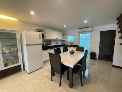 a kitchen with a table and a white refrigerator at Villa Luxe AP06 in Kamala Beach