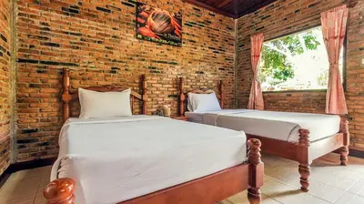 two beds in a room with a brick wall at Doo Dee Boutique Resort by Swiss Chalet in Ao Nang Beach