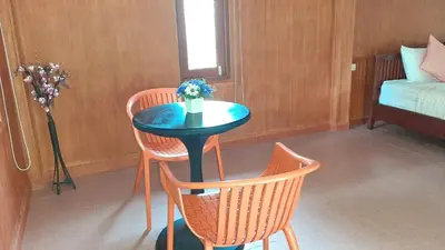 a small table with two chairs and a vase of flowers at Doo Dee Boutique Resort by Swiss Chalet in Ao Nang Beach