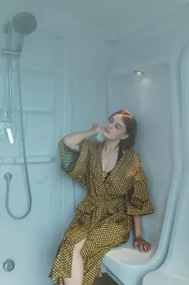 a woman sitting on a toilet in a bathroom at Hilltop Wellness Resort Phuket in Phuket Town