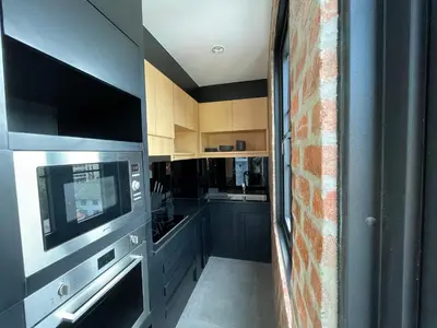 a kitchen with gray cabinets and a microwave at Room Actually Service Apartment in Karon Beach