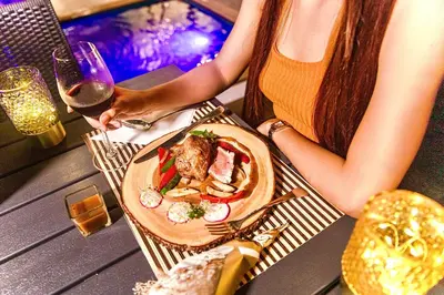 a woman sitting at a table with a plate of food at Tour De Phuket Hotel - SHA Plus in Thalang