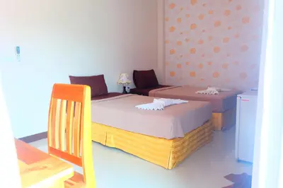 a bedroom with two beds and a table and a chair at Tubkaek mansion in Tab Kaek Beach
