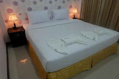 a large white bed with two bow ties on it at Tubkaek mansion in Tab Kaek Beach