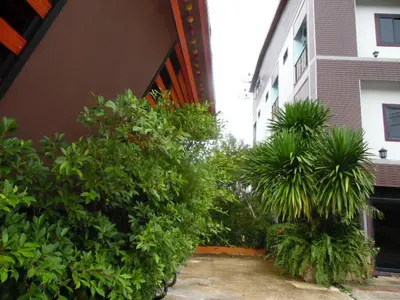 a garden with plants and trees next to a building at Tubkaek mansion in Tab Kaek Beach