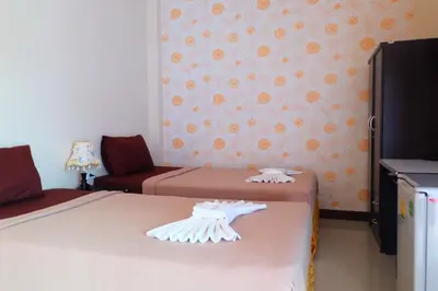 a bedroom with two beds and a wall with orangeprints at Tubkaek mansion in Tab Kaek Beach