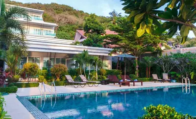a swimming pool with chairs and a building at Davina Beach Homes in Panwa Beach