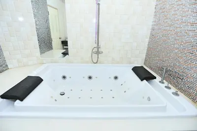 a large white bath tub in a bathroom at Lucky Sun Patong in Patong Beach
