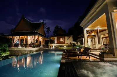 a villa with a swimming pool at night at Villa Salika in Rawai Beach