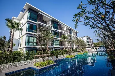 a hotel with a swimming pool in front of a building at The Title Beach Front in Rawai Beach
