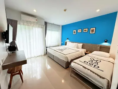 a bedroom with two beds and a blue wall at Ideo Phuket Hotel - Naiyang Beach in Nai Yang Beach