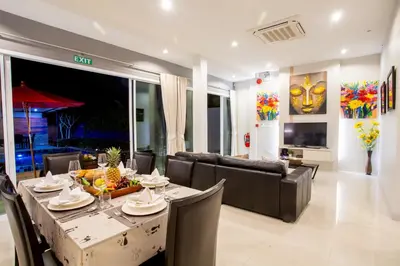 a dining room with a table and a couch at 3 Bedroom Exclusive Private Pool Villa Smooth as Silk in Ao Nang Beach