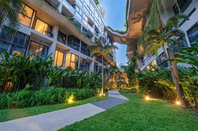 an apartment building with a pathway and palm trees at HOMA Phuket Town in Phuket Town