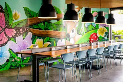 a dining room with a flower mural on the wall at HOMA Phuket Town in Phuket Town