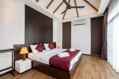a bedroom with a large bed and a ceiling fan at Shanti Villas x MonthStayZ Thailand in Rawai Beach