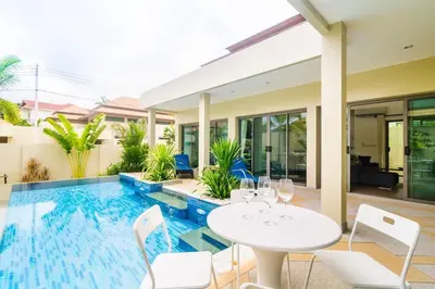 a patio with a white table and chairs and a swimming pool at Shanti Villas x MonthStayZ Thailand in Rawai Beach