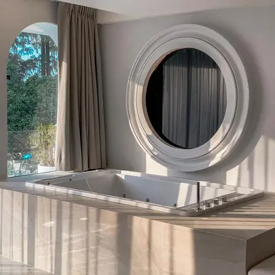 a bathroom with a tub and a large mirror at Anona Beachfront Phuket Resort-SHA EXTRA PLUS in Patong Beach