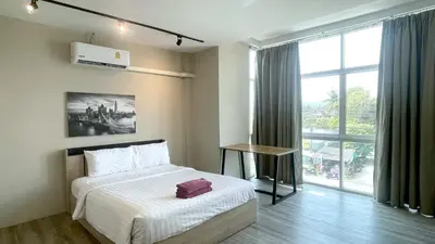 a bedroom with a bed and a large window at Breakers Hotel Rawai in Rawai Beach