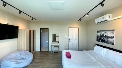 a hotel room with a bed and a television at Breakers Hotel Rawai in Rawai Beach