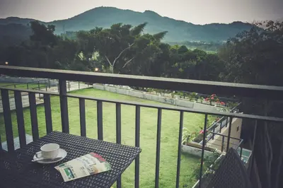 a table with a cup of coffee on a balcony at Studio apartments on a hill in Kathu