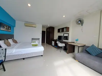a bedroom with a bed and a desk and a couch at Baan Oui guest house - Nai Harn in Phuket Town