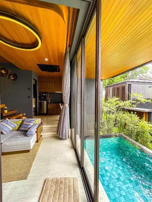 a house with a swimming pool and a living room at AKRA Collection Layan - Hideaway Villas in Layan Beach