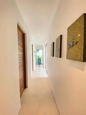 a hallway of a house with paintings on the walls at Anchan Grand Residence Villa in Phuket Town