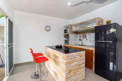 a kitchen with a red stool in front of a counter at Sabai Villas, 7 min drive from Naiharn & Rawai, Private pool, Four villas available in Rawai Beach