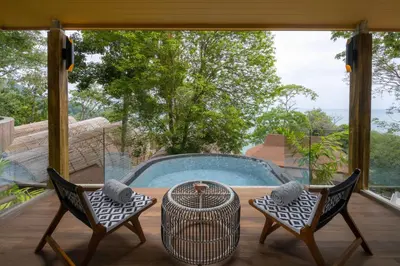 a patio with a table and two chairs and a pool at SINAE Phuket Luxury Hotel in Phuket Town