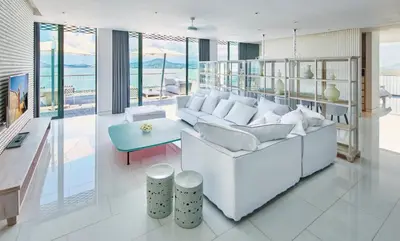 a living room with a white couch and a table at COMO Point Yamu, Phuket in Ban Pa Khlok
