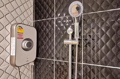 a bathroom with a hair dryer and a mirror at TJ Patong Hotel - Otop Shopping Paradise in Patong Beach