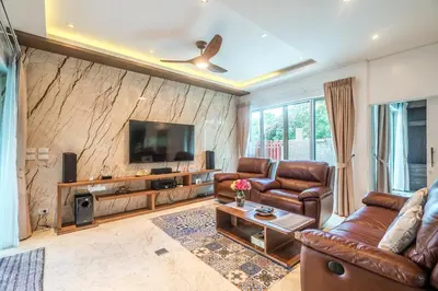 a living room with leather furniture and a tv at Villa Stan in Kamala Beach