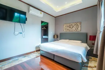a bedroom with a bed and a flat screen tv at Villa Stan in Kamala Beach