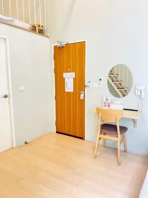 a room with a wooden door and a table and a chair at THE BELONG BOUTIQUE HOTEL in Phuket Town