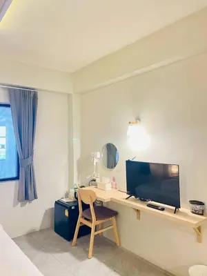 a room with a desk with a television and a chair at THE BELONG BOUTIQUE HOTEL in Phuket Town