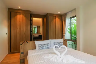 two white swans are sitting on a bed at Shambhala grand villa by Cozy Lake in Bang Tao Beach