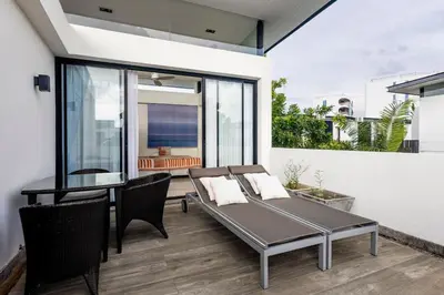 a patio with a table and chairs and a dining room at Hot! Laguna Park 5BR Modern Pool Villa - Bangtao Beach in Bang Tao Beach