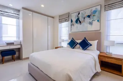 a bedroom with a large white bed with blue pillows at Hot! Laguna Park 5BR Modern Pool Villa - Bangtao Beach in Bang Tao Beach