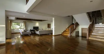a living room with a couch and a table and stairs at Villa Yoosook in Patong Beach