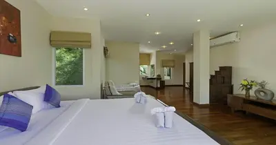 a bedroom with a large white bed with towels on it at Villa Yoosook in Patong Beach