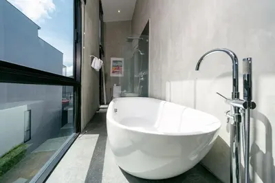 a white bath tub in a bathroom with a window at Villa Lami - Luxury 3-Bedroom Modern Villa in Phuket with Private Pool, Gym & Sauna in Phuket Town
