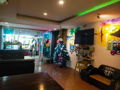 a living room with a christmas tree in it at Popeyes Hostel Patong in Patong Beach