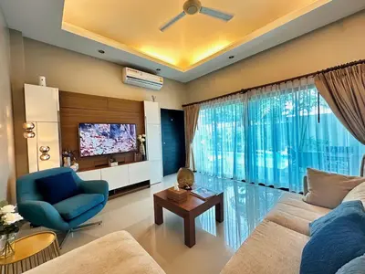 a living room with a blue couch and a tv at Villa Tara nr Layan Beach in Bang Tao Beach