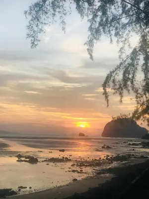 a sunset on the beach with the sun setting at Koh Yao Yai Sea Breeze House เกาะยาวใหญ่ซีบรีซเฮ้าส์ in Ko Yao Yai