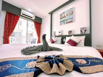 a hotel room with two beds with towels on them at Hotel Baya Phuket in Patong Beach
