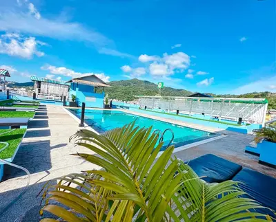 a pool at the resort with mountains in the background at Hotel Baya Phuket in Patong Beach